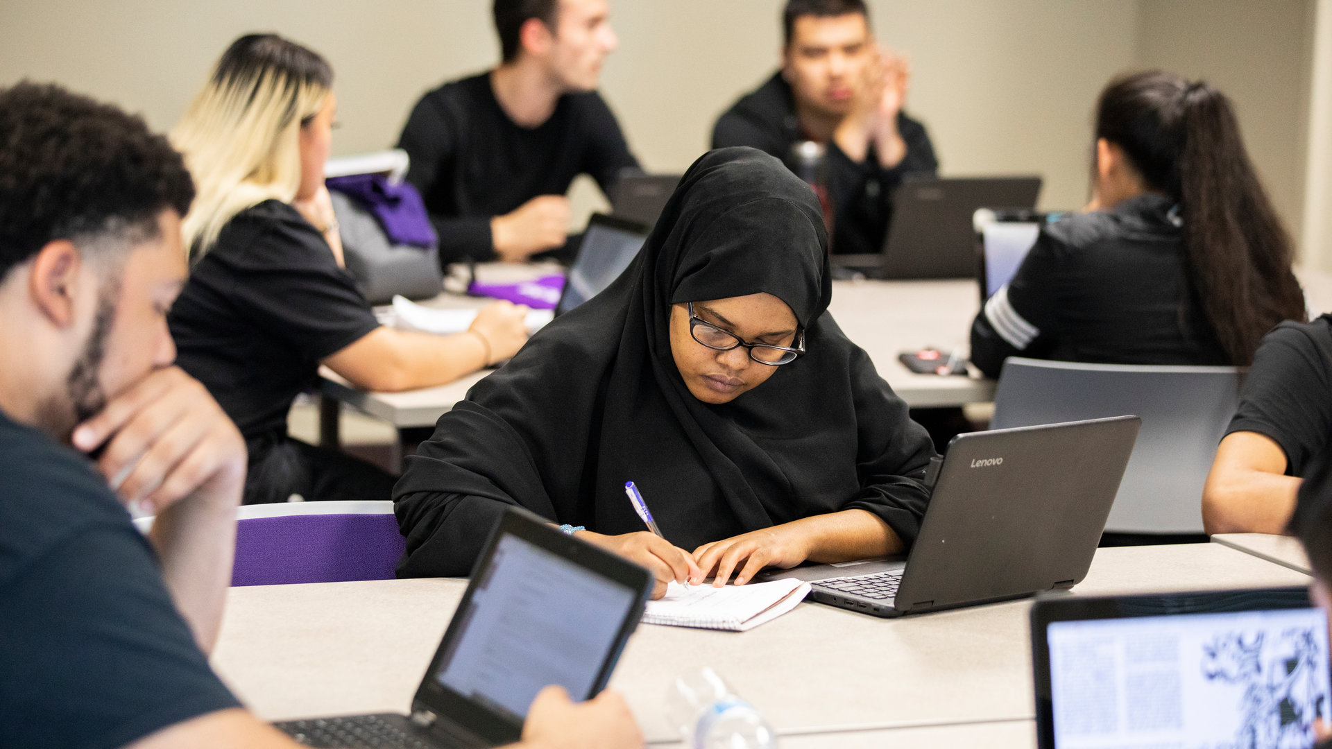 female student in black hijab studying
