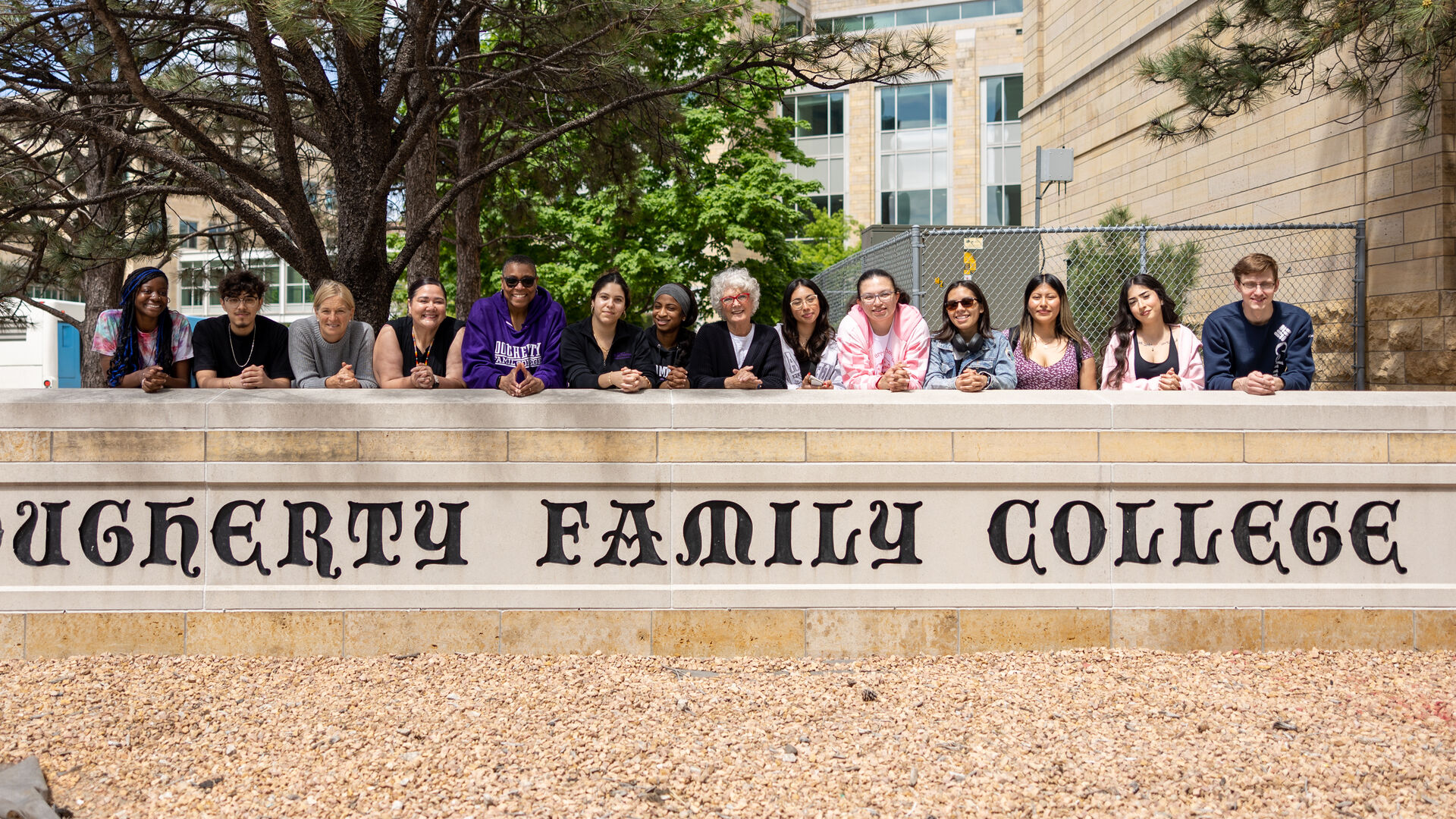 Dean Buffy Smith and students posing with the DFC outdoor sign