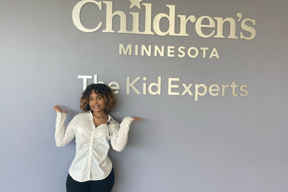 Rina Gonzalez in front of hospital sign at her internship at Children's Minnesota Hospital
