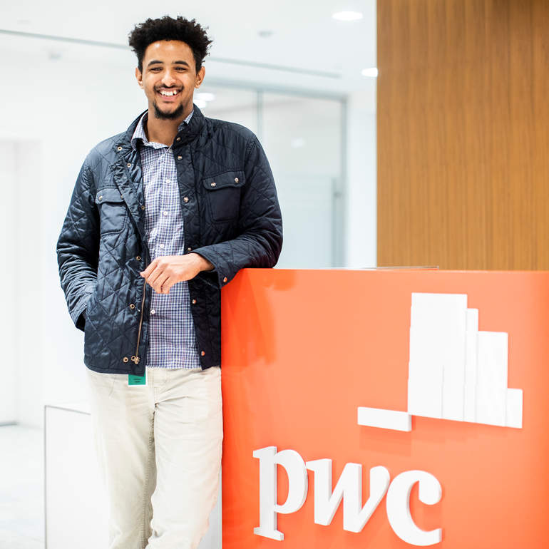 Student poses for a portrait at the PricewaterhouseCoopers (PwC)