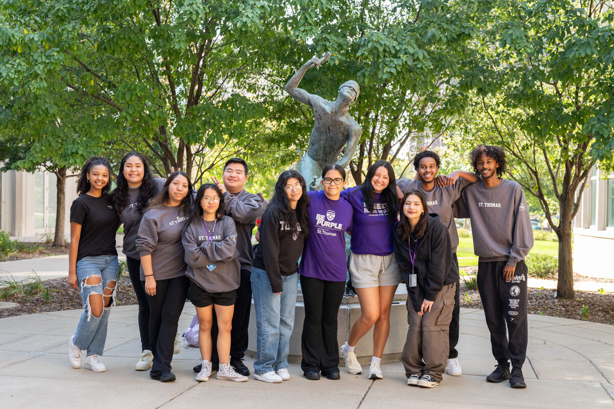 Group of students standing outside with arms around each other