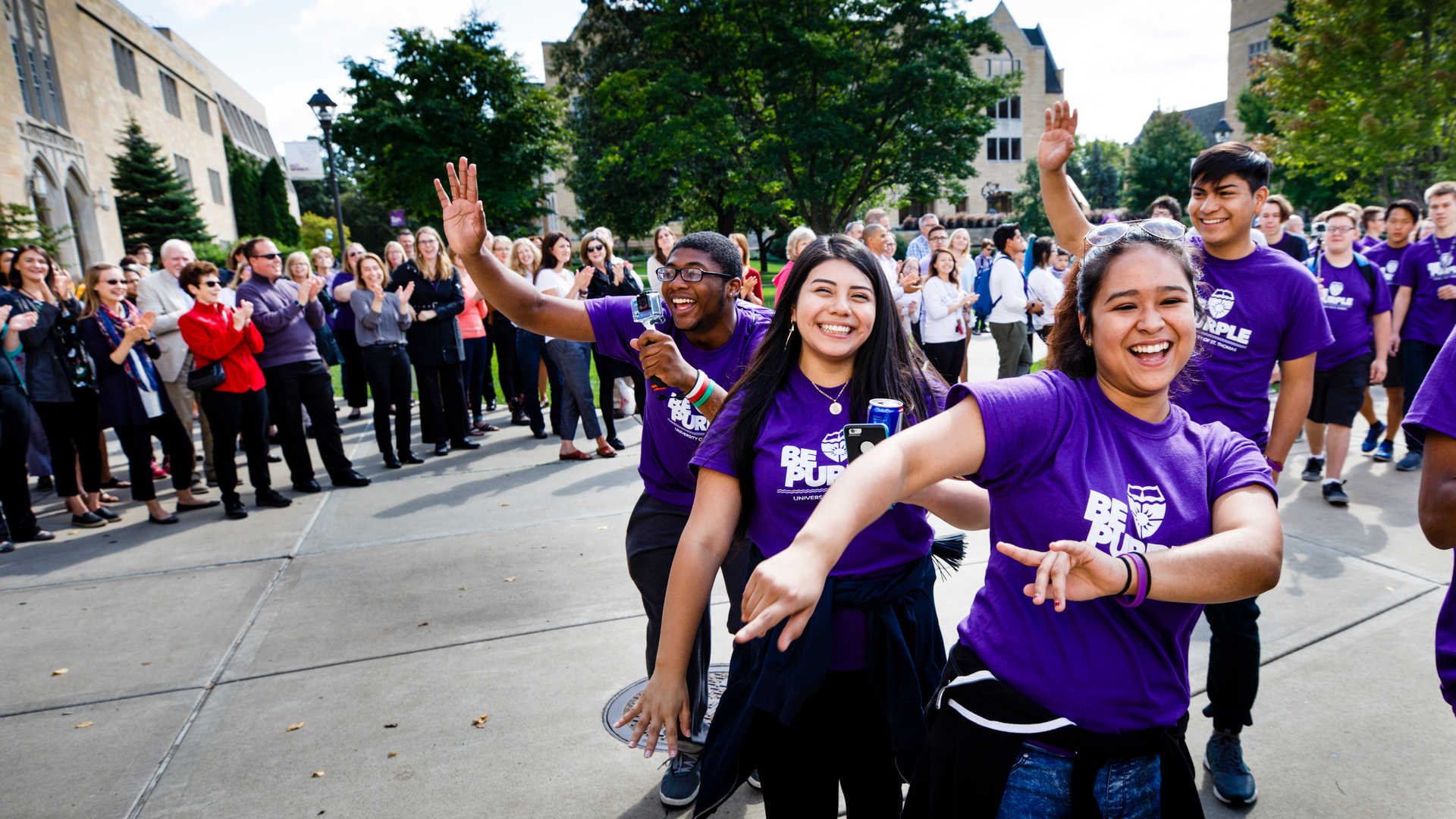 Students wearing "Proud to be Purple" shirts during march through arches