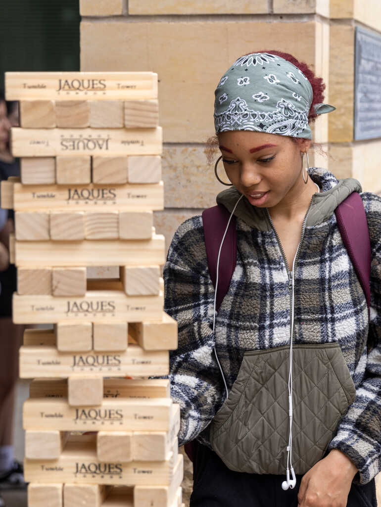 female student playing giant janga at dfc block party