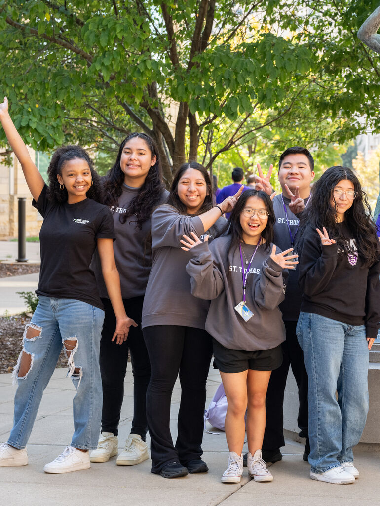 Group of six students doing funny poses on the quad outside on Minneapolis campus
