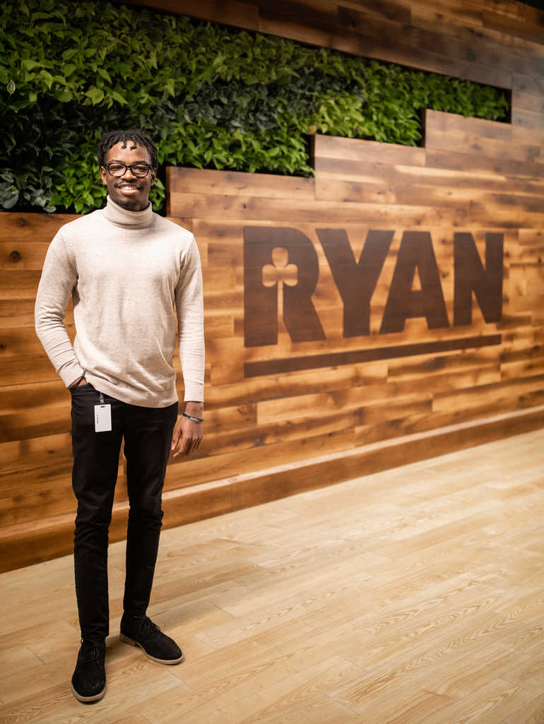 DFC intern standing in front of Ryan Companies logo