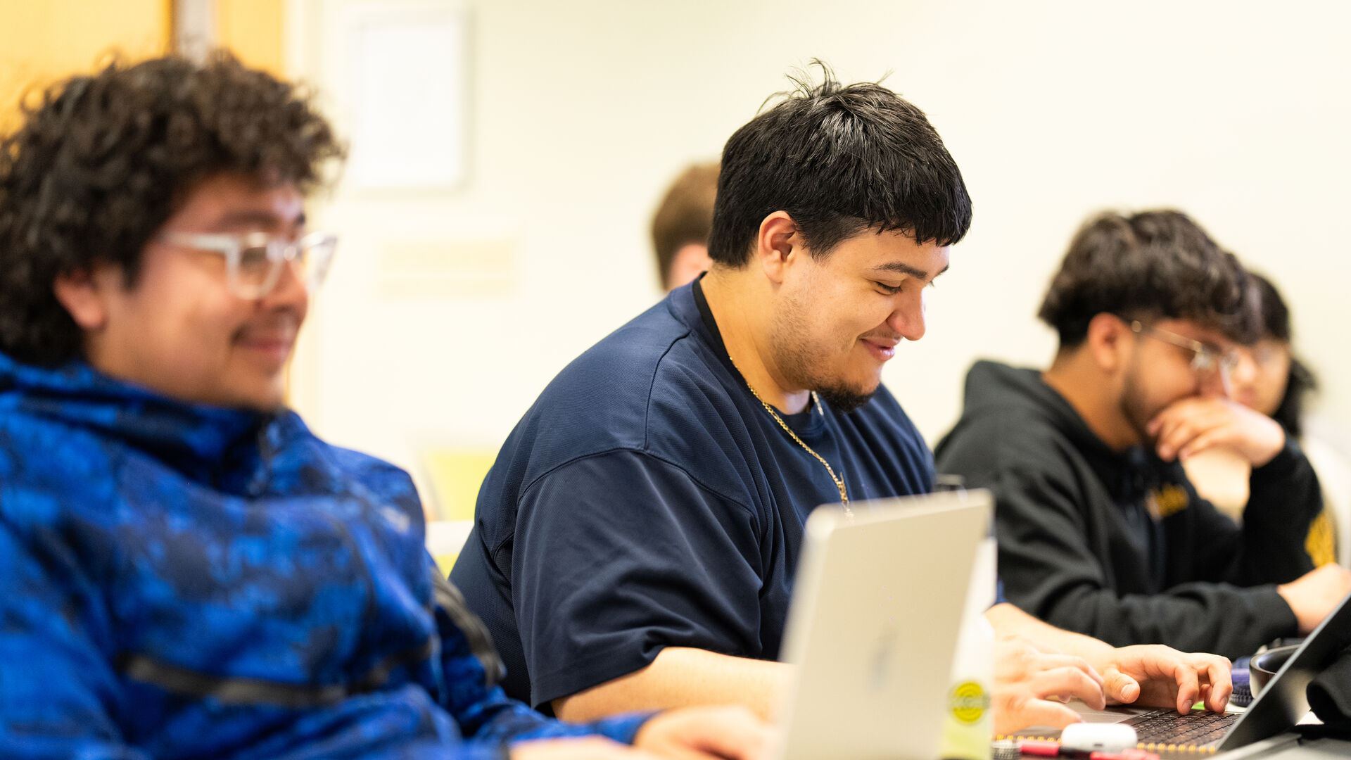 DFC student smiling at laptop during class